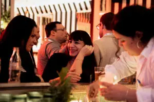 Three women enjoy drinks at a lively Barcelona bar—perfect for corporate events by MIT Creators, your expert DMC.
