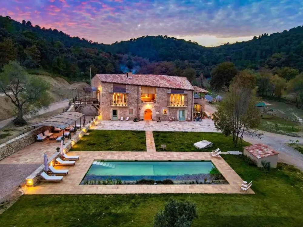 farmhouse hotel with swimming pool surrounded by mountains and nature